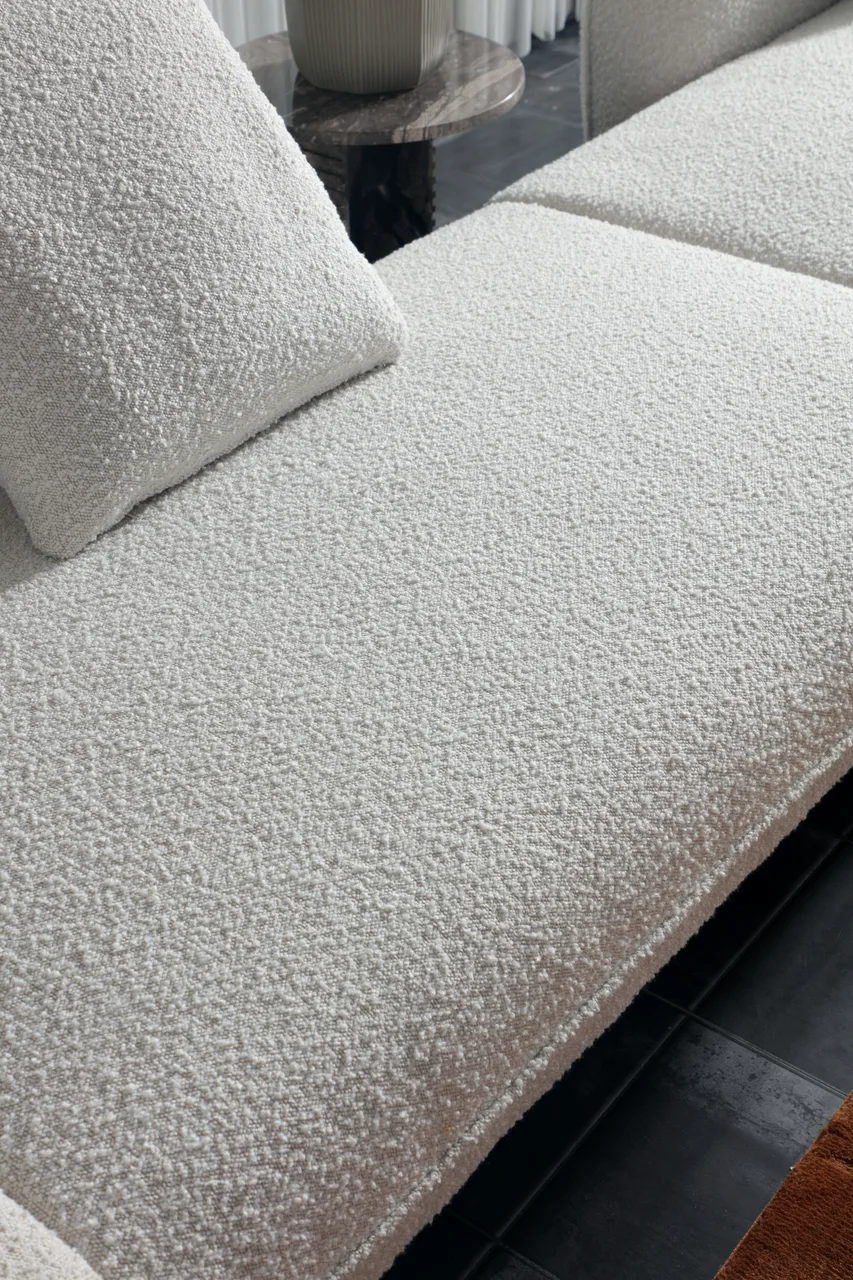 Close view of textured light upholstery across a sofa seat and cushion
