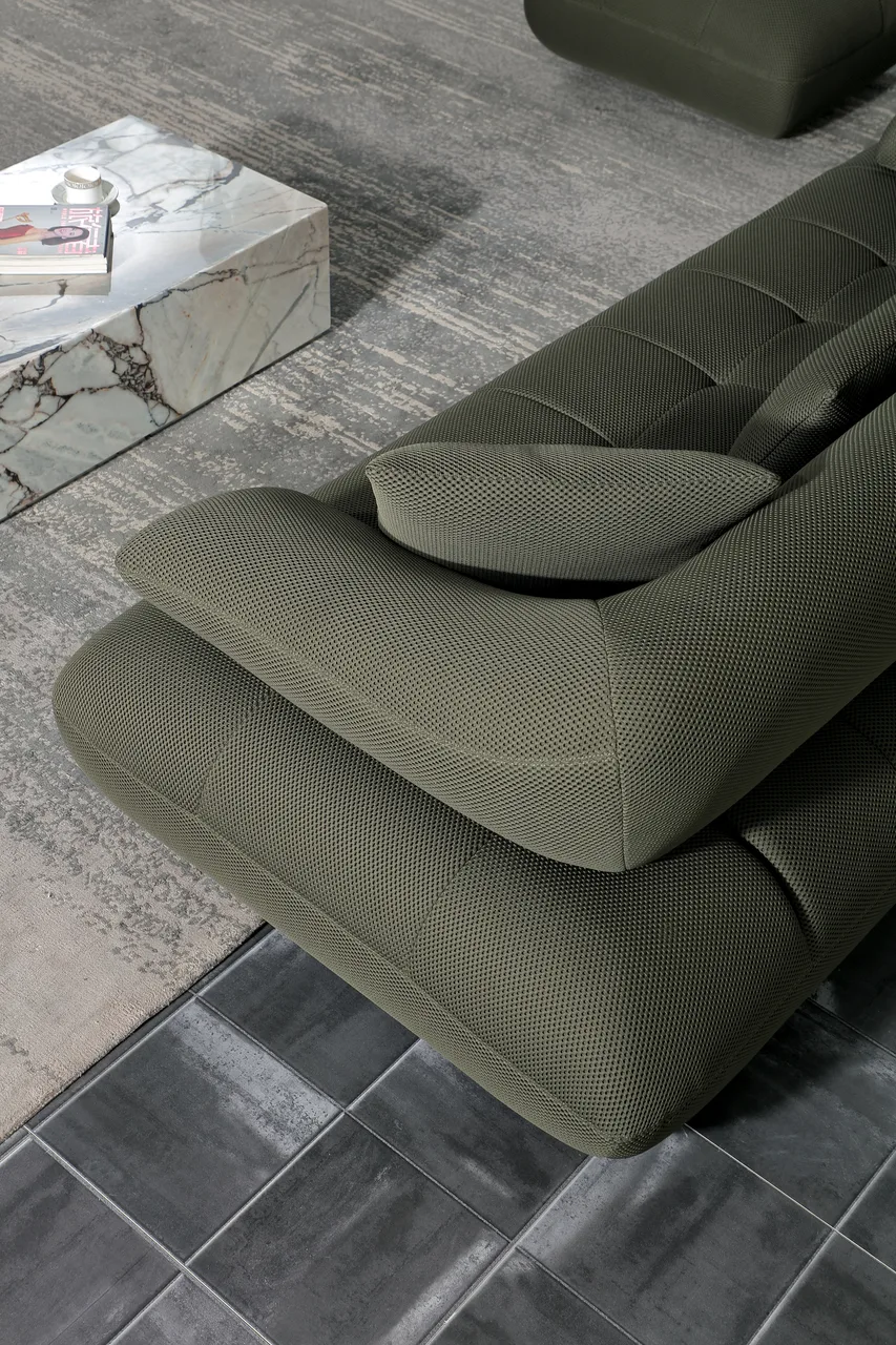 Close view of olive-green upholstery, rounded cushions and the sofa arm